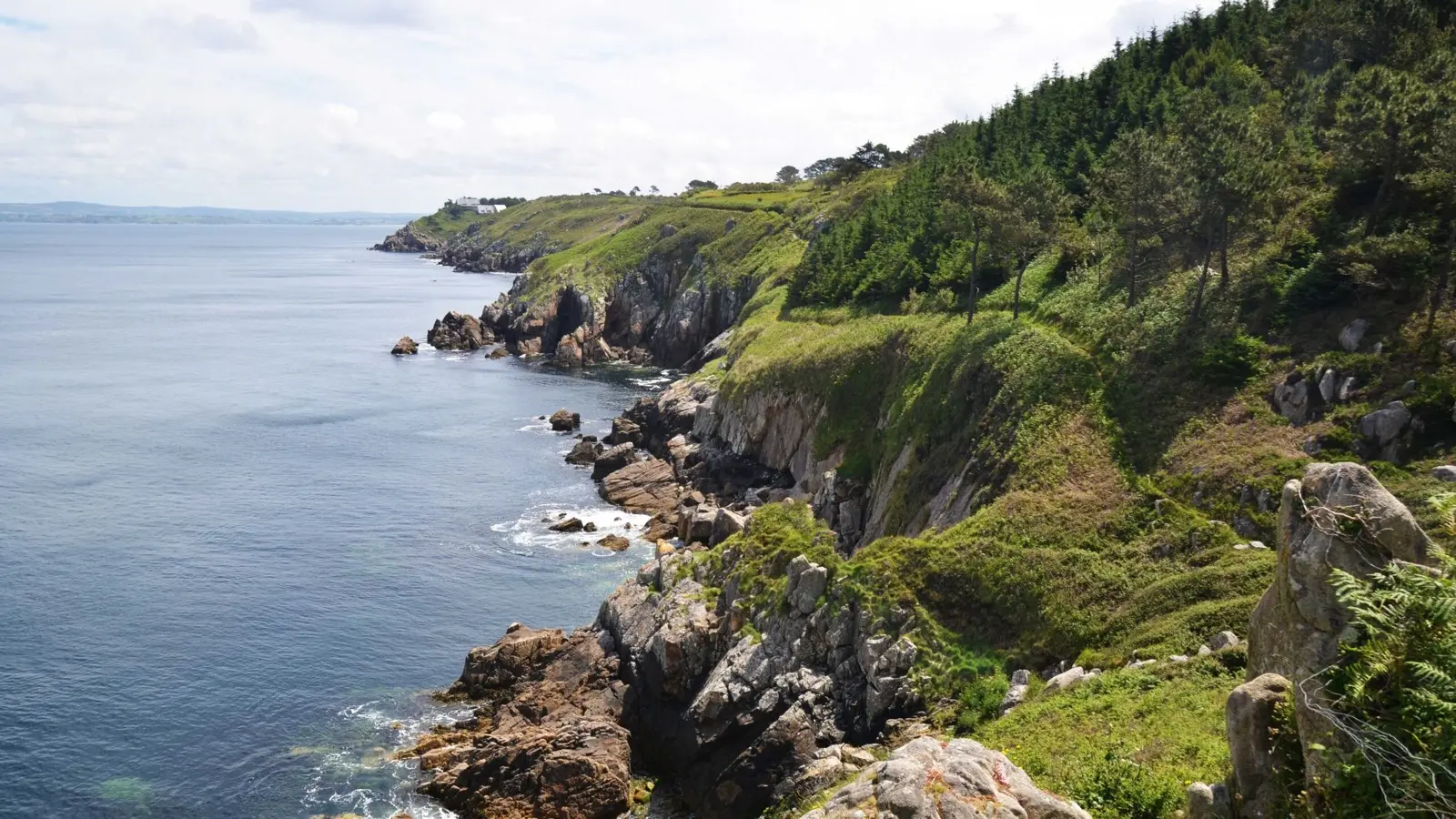 Falaises de quartz blanc et végétation sur le sentier côtier des Roches Blanches à Douarnenez, vue sur la baie