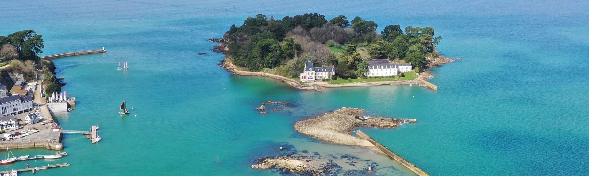 Vue aérienne d'une île sauvage bretonne depuis la mer, côte découpée et landes préservées